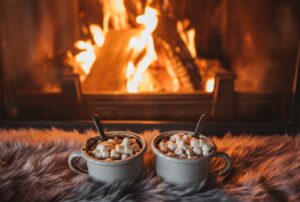 Cozy indoor scene with a fireplace, blankets, and hot chocolate, representing winter comfort. Trust Rellaire for reliable HVAC repair near me in Lodi, CA.